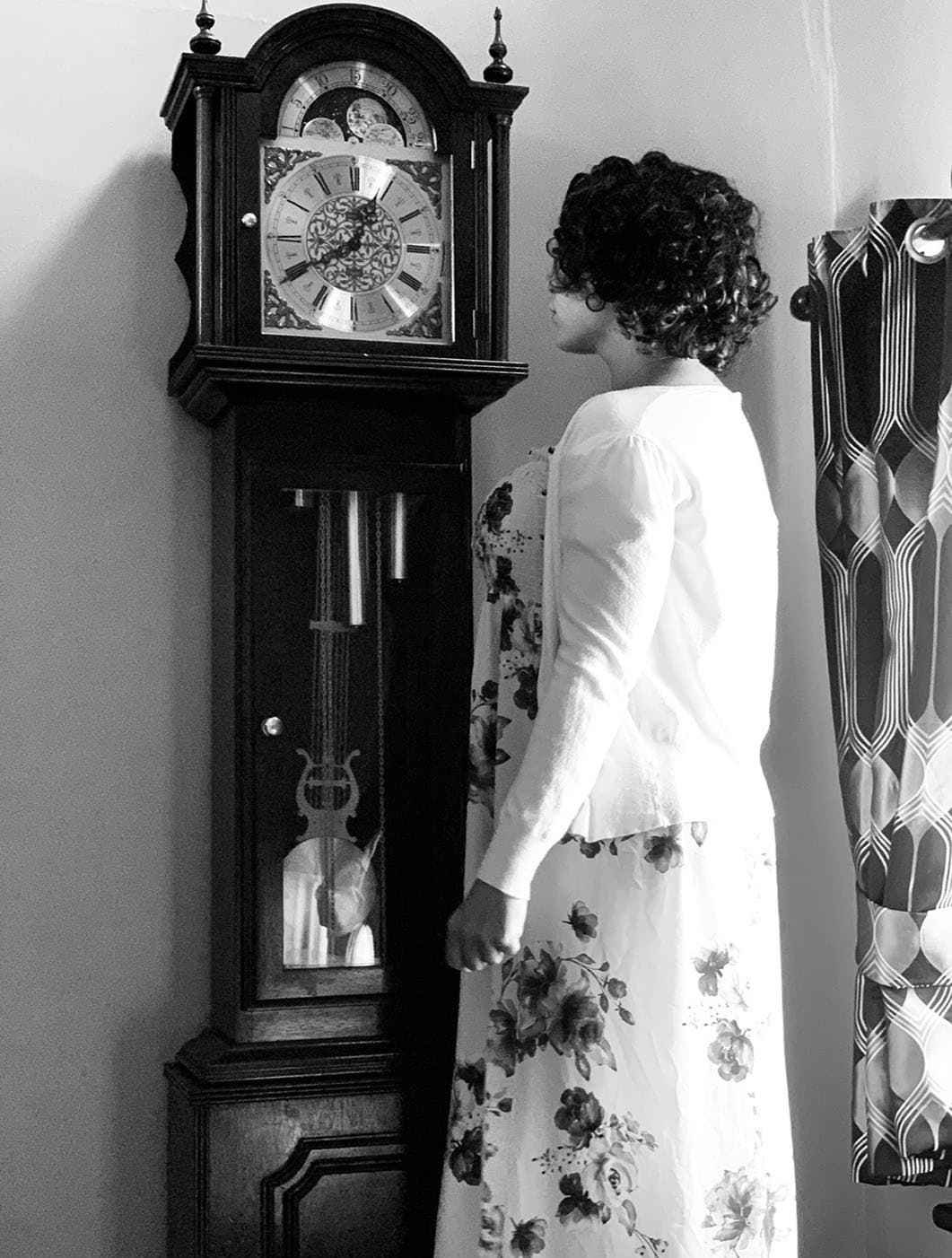 Bianca in a reflective moment beside a grandfather clock